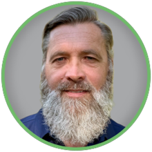 Alan Darsey Headshot mit grauem Hintergrund und grünem Kreisrand