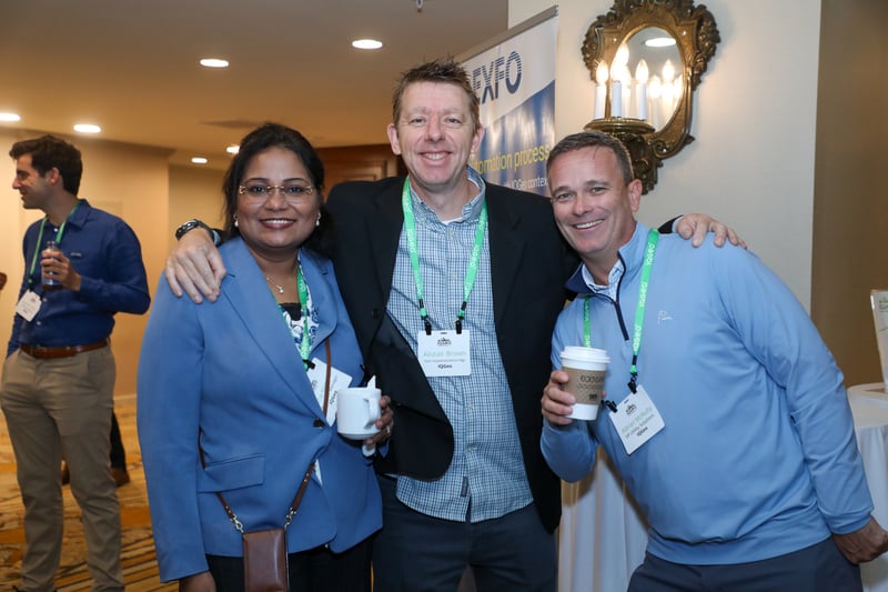 Drei Delegierte auf dem IQGeo Americas Meetup 2025 lächeln in die Kamera