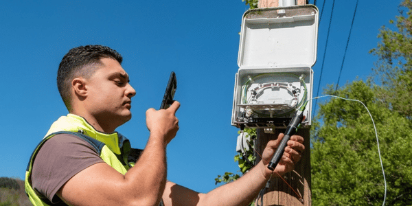 IQGeo – Telekommunikations-Außendiensttechniker mit mobilem Gerät – 600x300